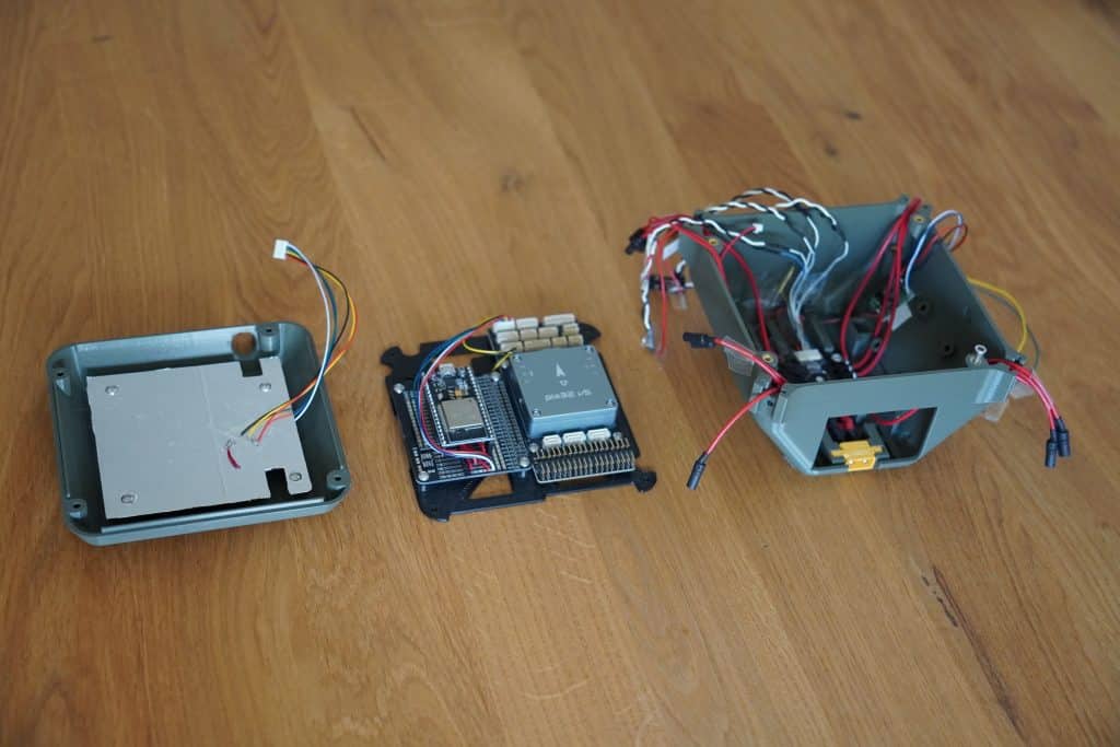 3d printed drone frame. Left to right: Top cover with integrated GPS module and reflector; pix32V5 flight controller with DroneBridge for ESP32 transmitter; main frame with ESC and power-train connections